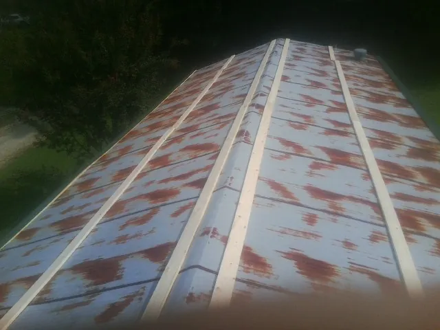 Rusted metal roof panels with new wood purlins before replacement — Storm Damage Roof Repair in Bay Center by Roofing Brothers