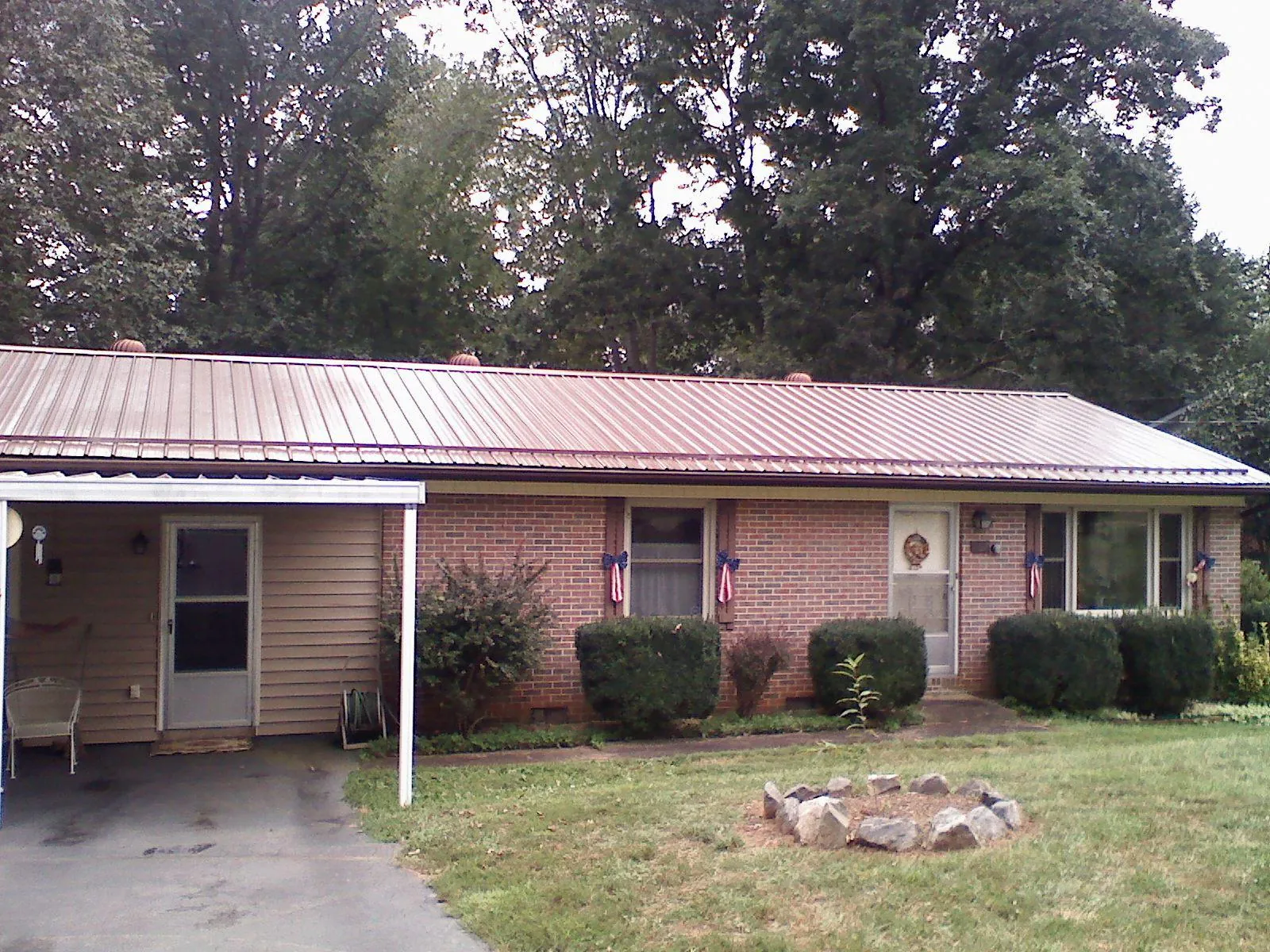 Bronze metal roof and carport on a brick ranch home — Roof Repair work by our crew in Bay Center